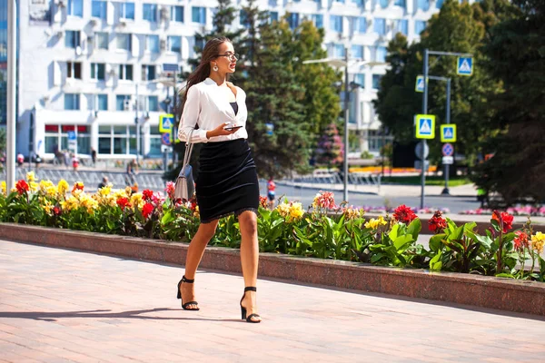 Mujer morena de negocios caminando en la calle de verano — Foto de Stock