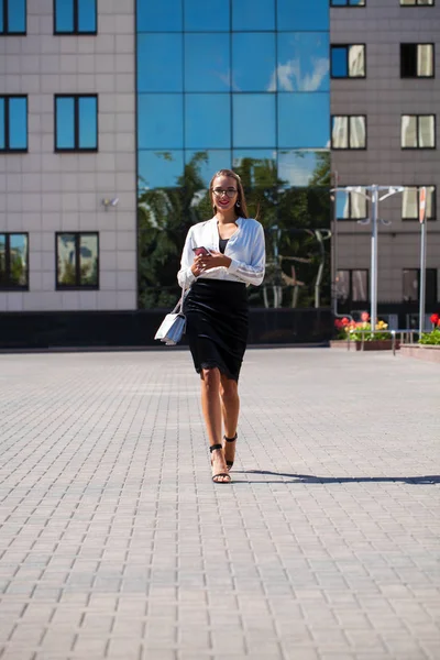 Mladá bruneta žena čtení zpráv na telefonu — Stock fotografie