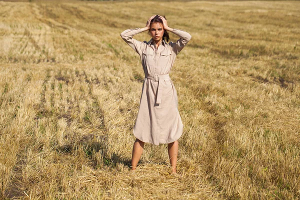 Giovane bella bruna modello in un abito beige in posa contro t — Foto Stock