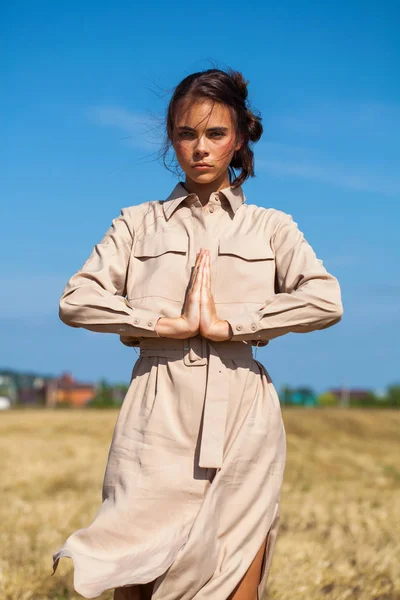 Junge schöne brünette Modell in einem beigen Kleid posiert gegen — Stockfoto