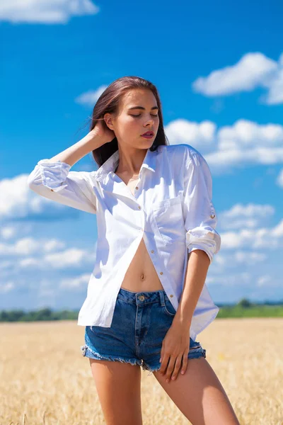 Beyaz gömlek ve mavi kot şort genç esmer kadın 