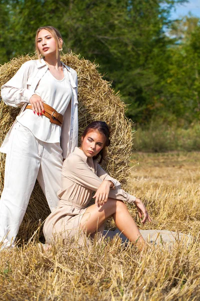 Ha bir arka plan üzerinde poz bej takım elbise iki güzel kız