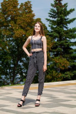 Sokakta yürüyen çizgili pantolon genç güzel kadın,