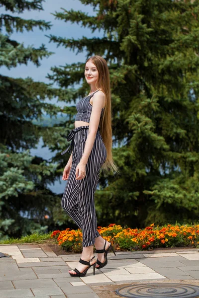 Sokakta yürüyen çizgili pantolon genç güzel kadın,