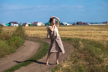 Haystac bir arka plan üzerinde poz bej takım elbise güzel kız