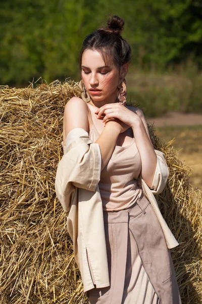 Joven modelo morena hermosa en un vestido beige posando contra —  Fotos de Stock