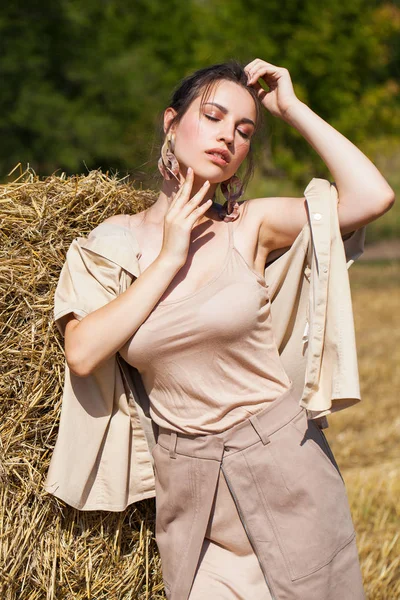 Joven modelo morena hermosa en un vestido beige posando contra — Foto de Stock