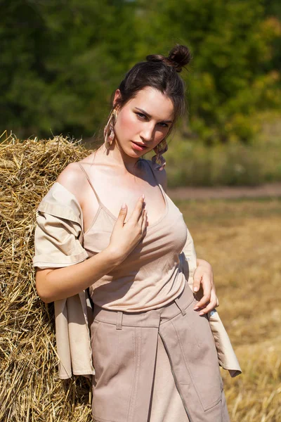 Joven modelo morena hermosa en un vestido beige posando contra — Foto de Stock