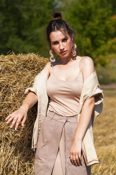 Joven modelo morena hermosa en un vestido beige posando contra — Foto de Stock