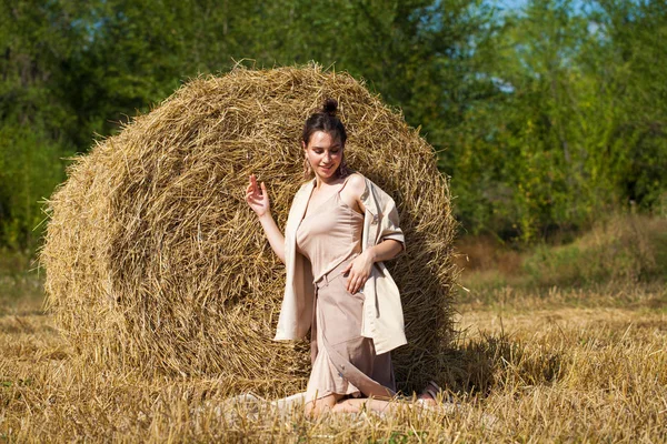 美丽的女孩在米色西装上摆姿势的背景干草 — 图库照片