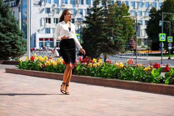 Business brunette woman walking in summer street — Stock Photo, Image