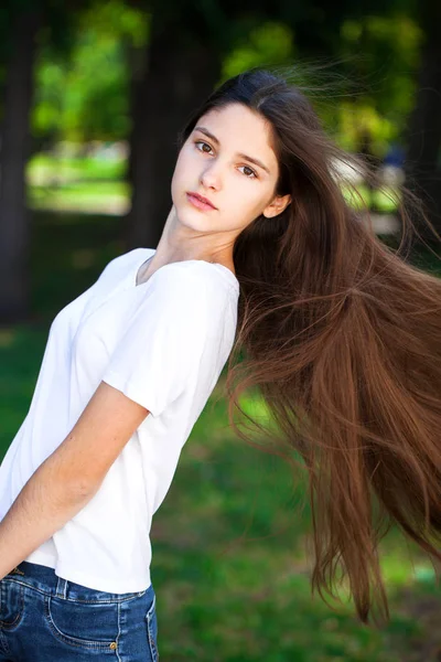 Vackra Brunette flicka i vit t-shirt på en bakgrunds — Stockfoto