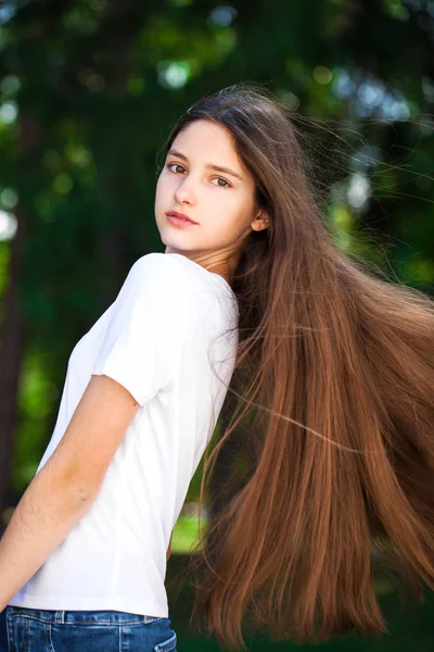 Vackra Brunette flicka i vit t-shirt på en bakgrunds — Stockfoto