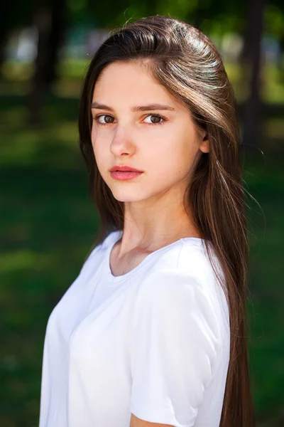 Vackra Brunette flicka i vit t-shirt på en bakgrunds — Stockfoto