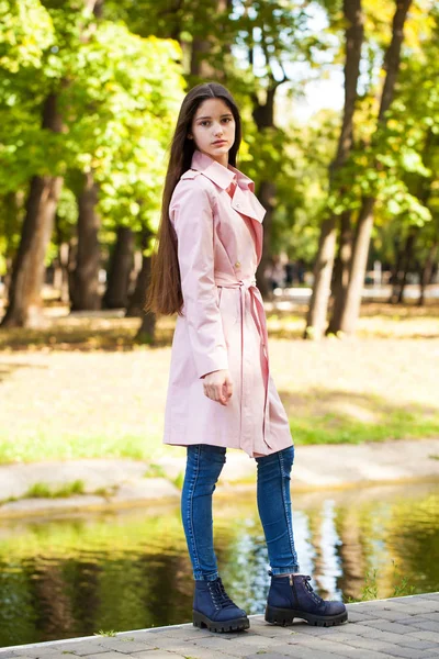 Portrét mladé brunetové dívky v růžovém plášti na pozadí — Stock fotografie