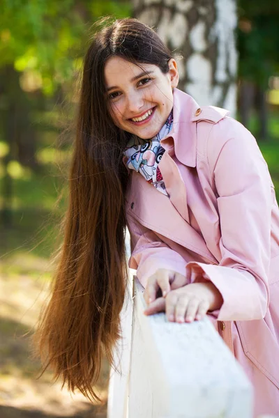 Retrato de una joven morena con abrigo rosa sobre un fondo o —  Fotos de Stock