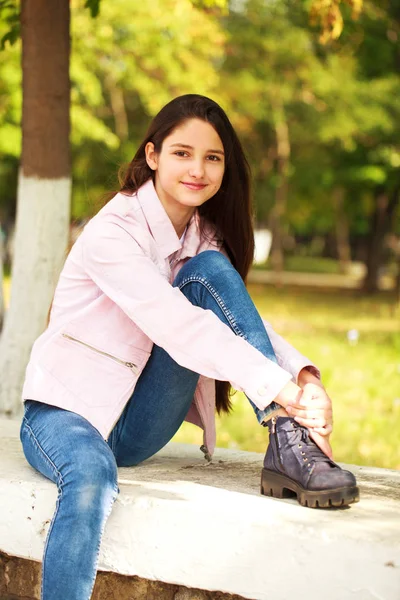 Portrét mladé dívky v růžovém kabátku na pozadí minule — Stock fotografie