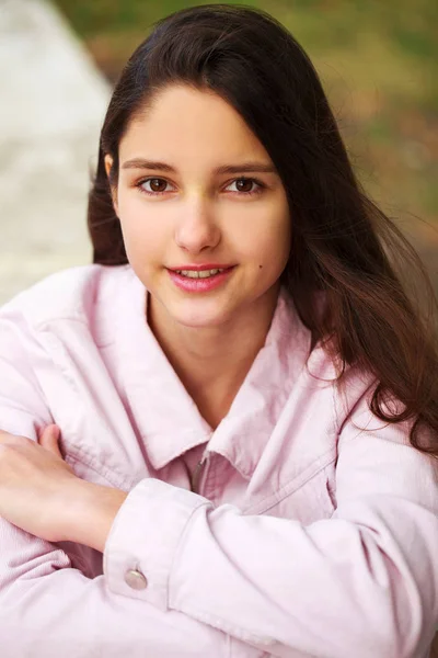 Retrato de uma jovem morena de casaco rosa em um fundo o — Fotografia de Stock