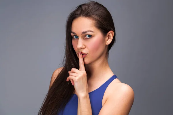Młoda kobieta piękny ma położyć palec wskazujący usta jako znak sile — Zdjęcie stockowe