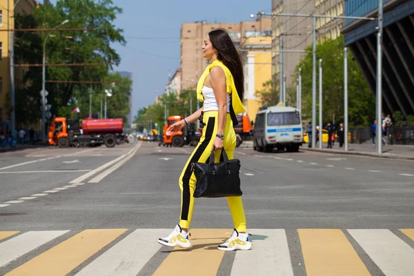 Portret van een jonge mooie brunette vrouw in gele trainingspak — Stockfoto