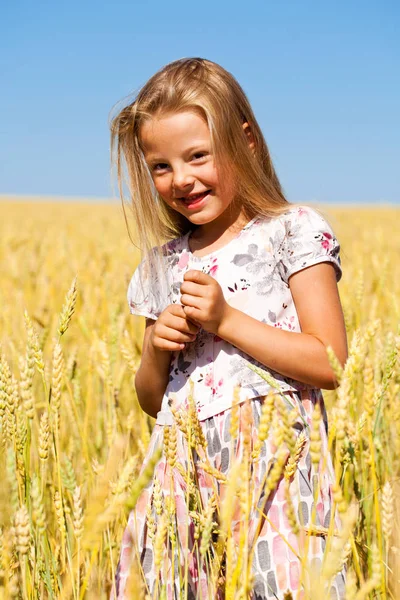 Kleines Mädchen in einem goldenen Weizenfeld — Stockfoto