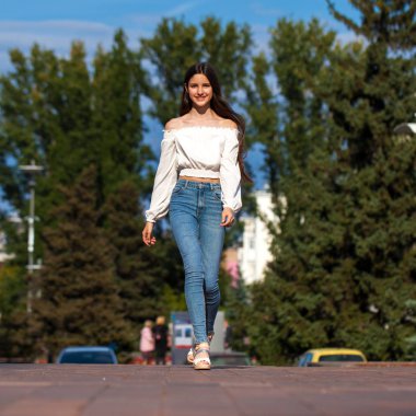 Kot pantolon ve beyaz bluz yürüyüş genç güzel esmer kadın