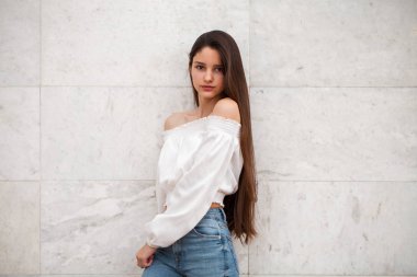 Beyaz mermer duvar bir arka plan genç güzel kız