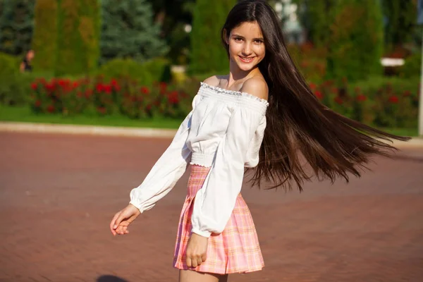 Chica morena bastante elegante en falda a cuadros y blusa blanca — Foto de Stock