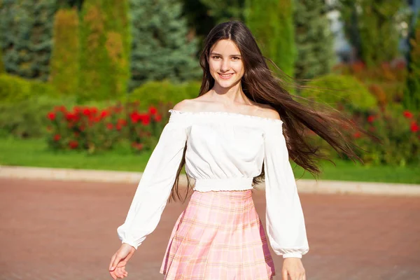 Jolie fille brune élégante en jupe à carreaux et chemisier blanc — Photo