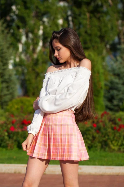 Pretty stylish brunette girl in plaid skirt and white blouse — Stock Photo, Image