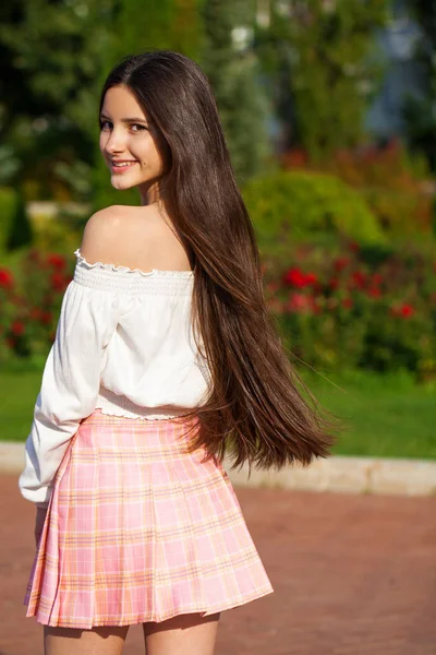 Досить стильна дівчина брюнетка в плетеній спідниці і біла блузка — стокове фото