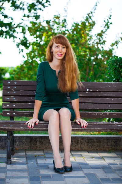 Linda jovem mulher de cabelo vermelho posando no parque de verão — Fotografia de Stock