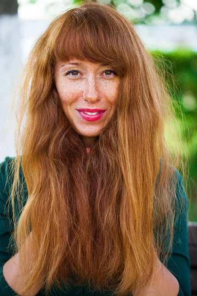 Schöne junge Frau mit rotem Haar posiert im Sommerpark — Stockfoto
