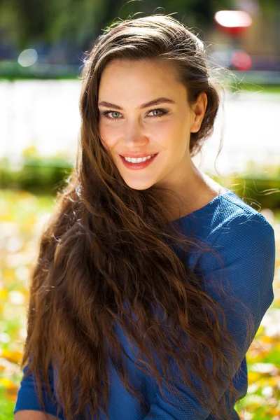 가을 공원에서 파란색 드레스에 젊은 아름다운 갈색 머리 여자 — 스톡 사진