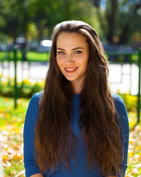 가을 공원에서 파란색 드레스에 젊은 아름다운 갈색 머리 여자 — 스톡 사진