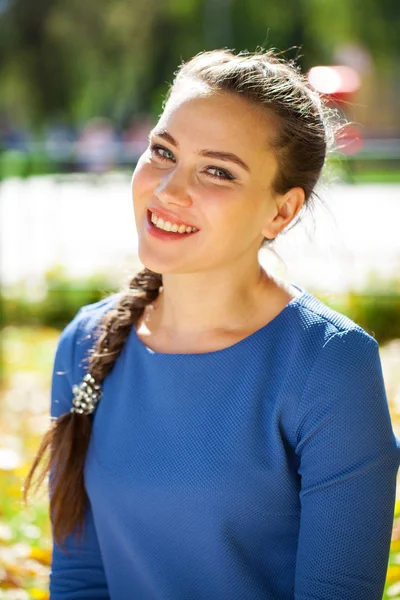 Joven hermosa mujer morena en vestido azul en el parque de otoño — Foto de Stock