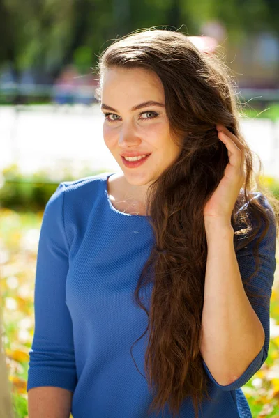 Fiatal gyönyörű barna nő kék ruhában ősszel parkban — Stock Fotó