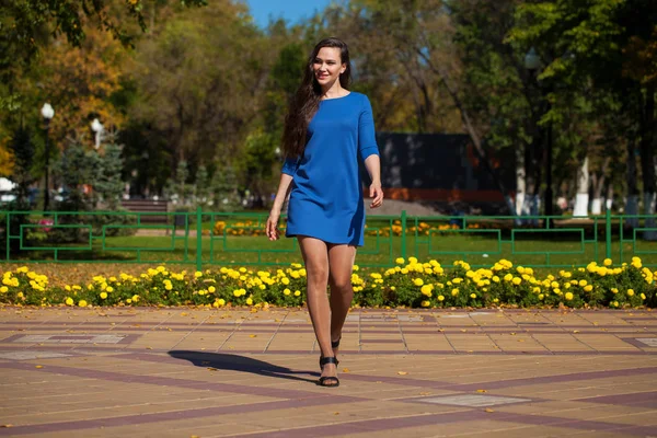 Jovem mulher bonita em vestido azul escuro andando no verão s — Fotografia de Stock