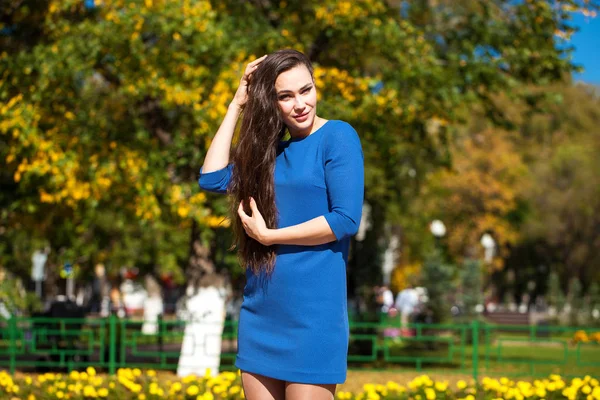 Mulher morena bonita em um vestido azul andando na rua , — Fotografia de Stock