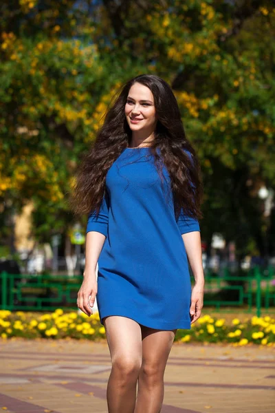 Jovem mulher bonita em vestido azul escuro andando no verão s — Fotografia de Stock