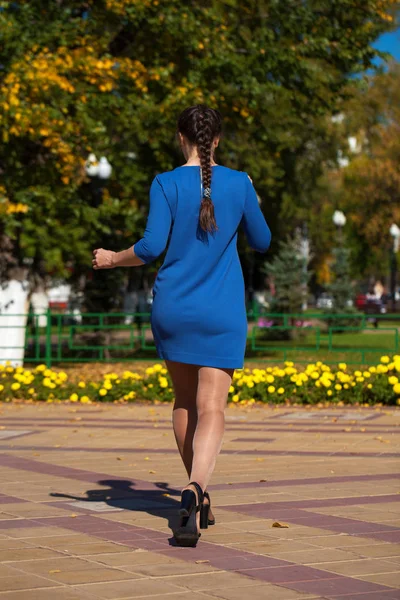 Jovem mulher bonita em vestido azul escuro andando no verão s — Fotografia de Stock