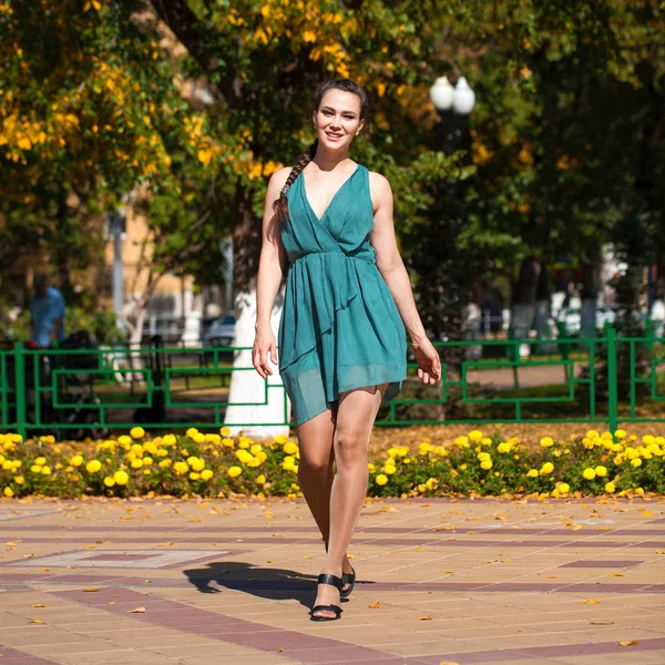 Junge schöne Frau in dunkelblauem Kleid, die auf dem Sommer spazieren geht — Stockfoto