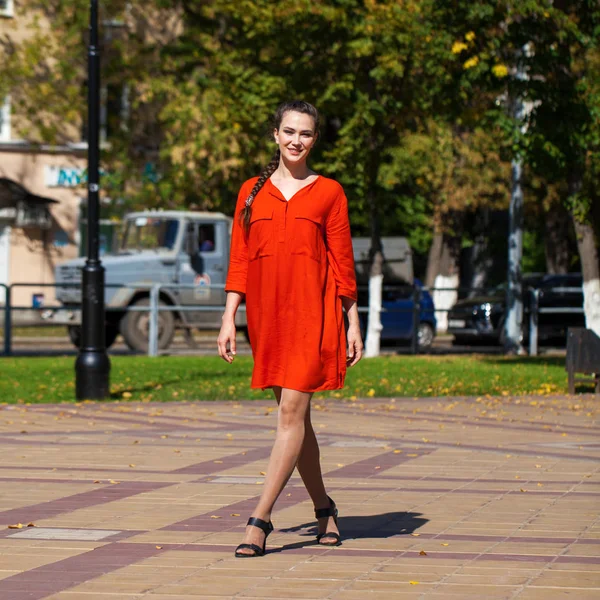 Tineri model frumos în rochie roșie mergând pe strada de vară — Fotografie, imagine de stoc