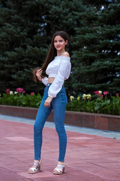 Pretty stylish brunette girl in blue jeans and white blouse — Stock Photo, Image