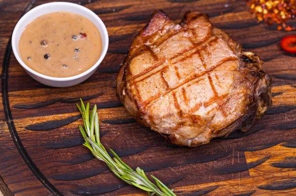 Bife de porco em uma placa de madeira — Fotografia de Stock