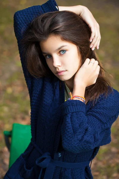 Pretty brunette little girl posing in autumn park background — Stock Photo, Image