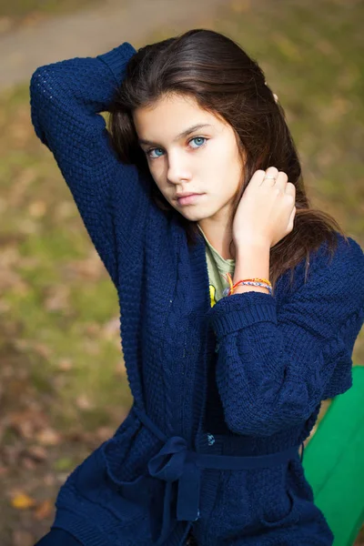 Linda niña morena posando en el fondo del parque de otoño — Foto de Stock