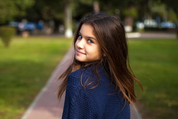 Linda niña morena posando en el fondo del parque de otoño — Foto de Stock