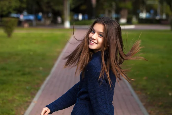 Ładna brunetka dziewczynka pozuje w jesiennym parku tle — Zdjęcie stockowe