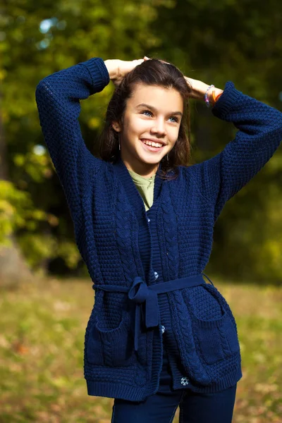 Linda niña morena posando en el fondo del parque de otoño — Foto de Stock